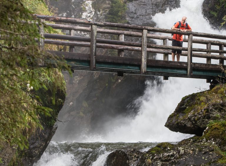Ein junger Mann ist auf einer Brücke auf dem Themenwanderweg Wilde Wasser im Untertal unterwegs. Das Wandererlebnis Wilde Wasser wurde als National Geographic Wanderweg ausgezeichnet. Fotocredit: Martin Huber