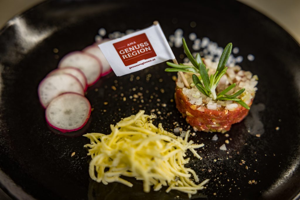 Essen mit einer Miniatur-Flagge und dem Logo AMA Genuss