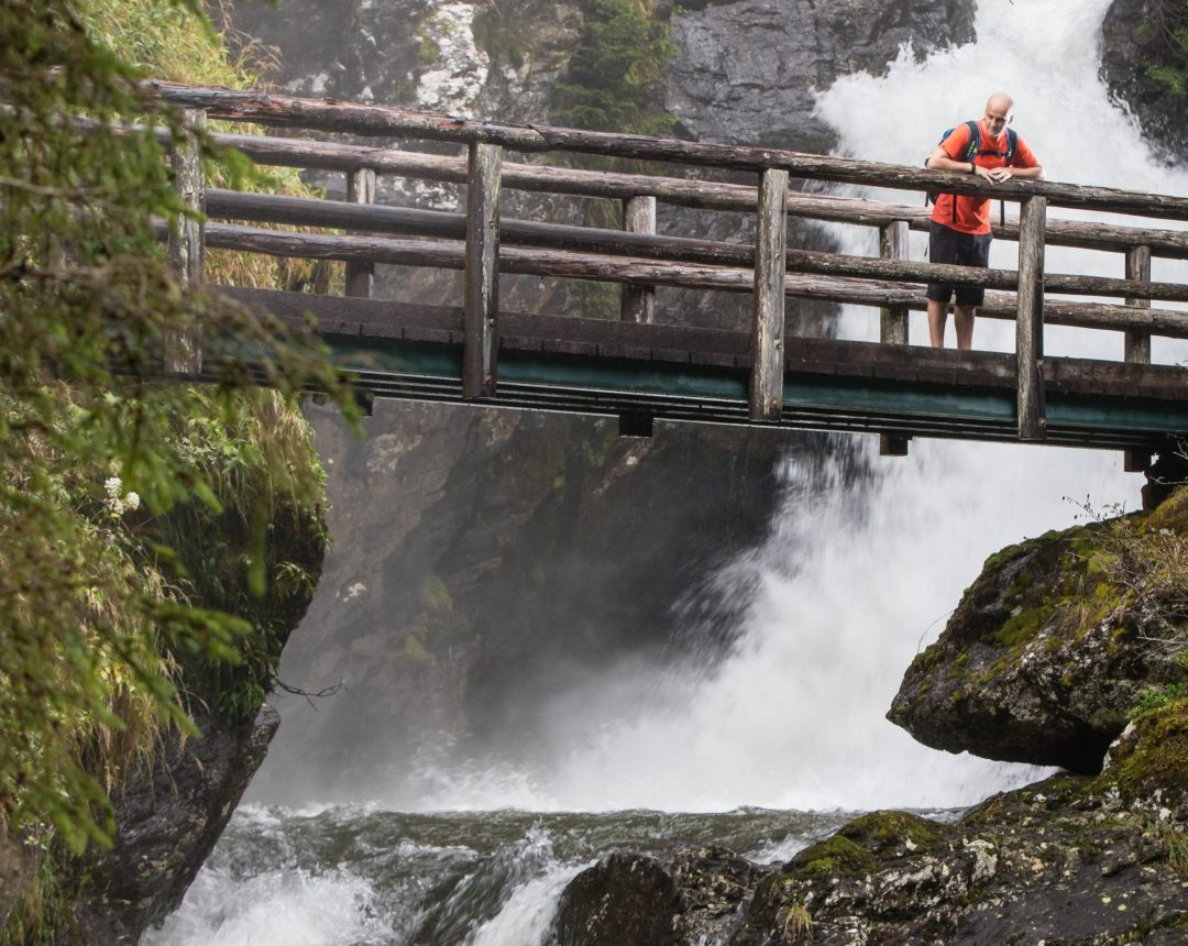 Ein junger Mann ist auf einer Brücke auf dem Themenwanderweg Wilde Wasser im Untertal unterwegs. Das Wandererlebnis Wilde Wasser wurde als National Geographic Wanderweg ausgezeichnet. Fotocredit: Martin Huber