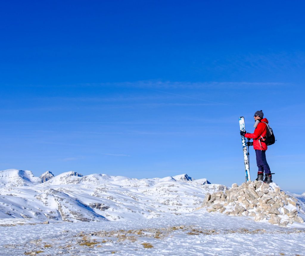 ein Skitouren-Geher auf dem Plateau des Gipfels Großes Tragl. Im Hintergrund Gipfel im Toten Gebirge wie beispielsweise Großer Priel im linken Bilddrittel, Blick in Richtung Nordosten.