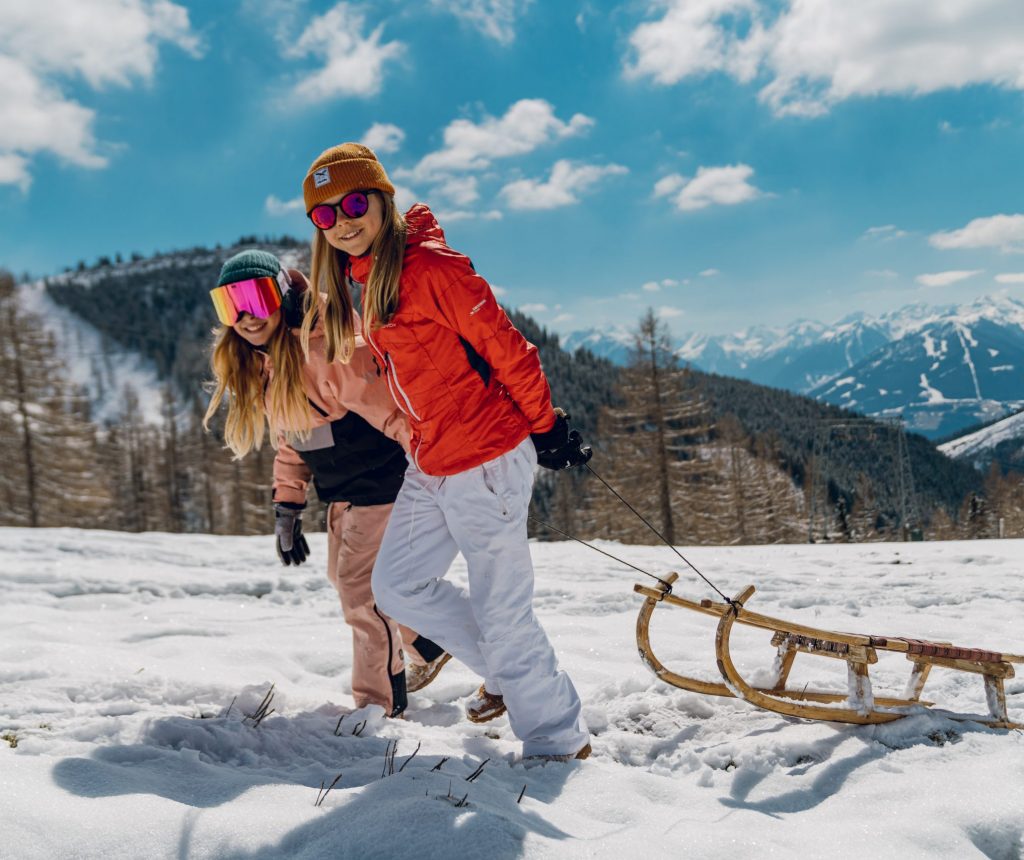 Ein Mann und eine Frau beim Rodeln im Winter
