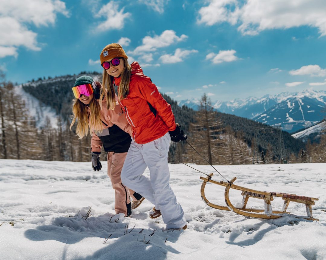 Ein Mann und eine Frau beim Rodeln im Winter